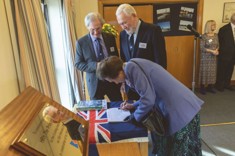 The Princess Royal signs the Visitors’ Book  at the Cruising Association, marking the CA's 110th Anniversary